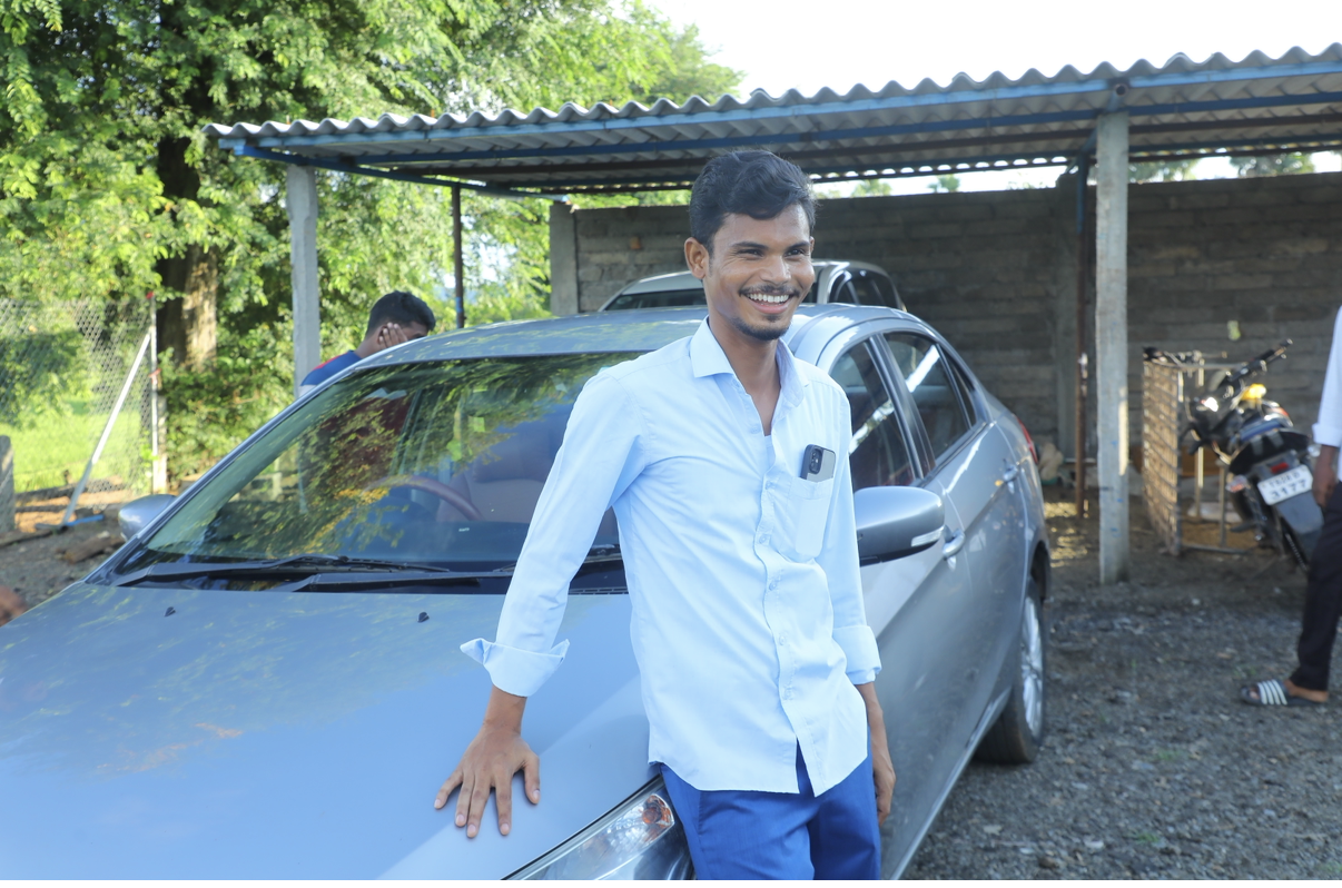 Local leader smiling beside the ministry car
