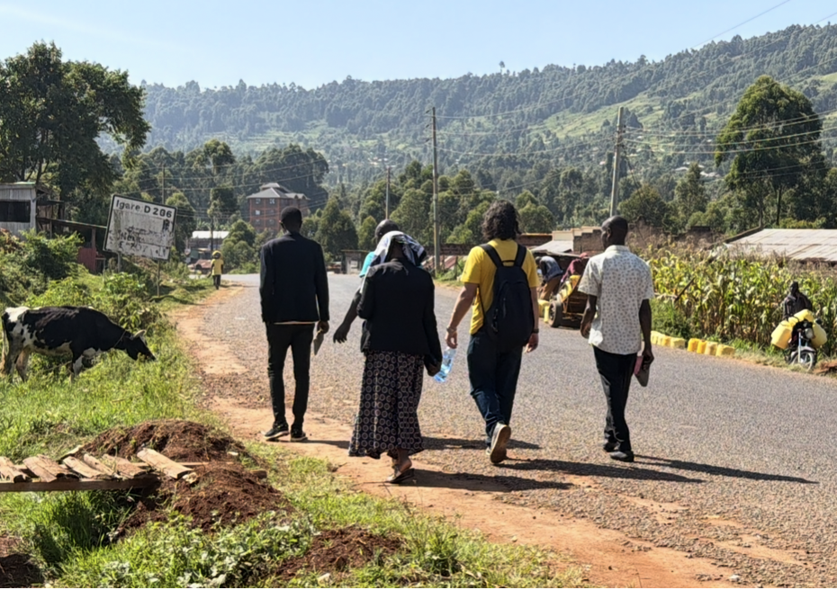 Team walking along a rural road to reach a village
