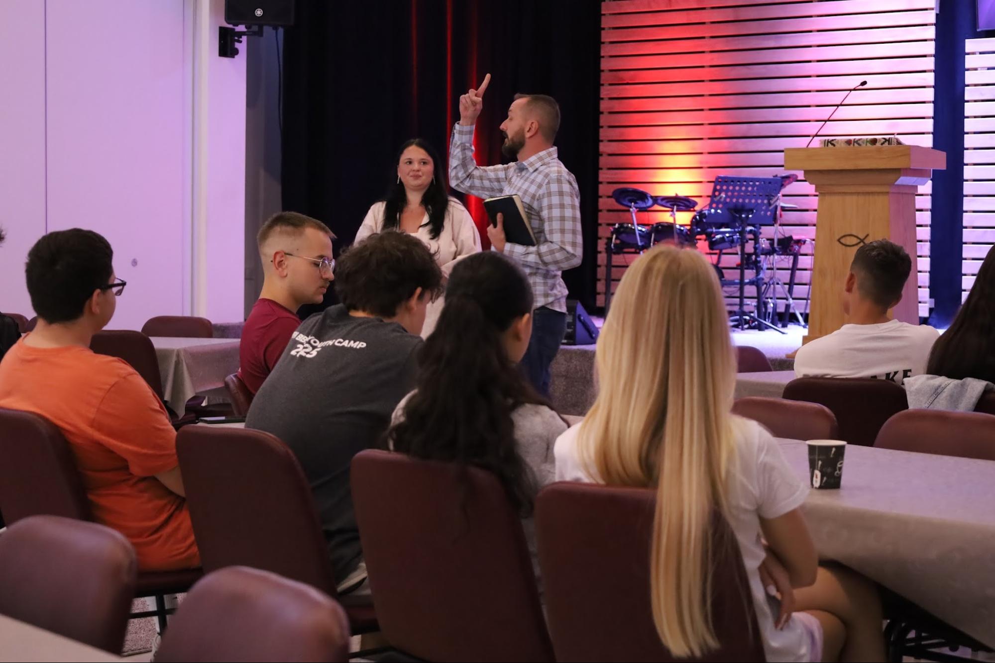 Pastor preaching from Scripture to a youth group