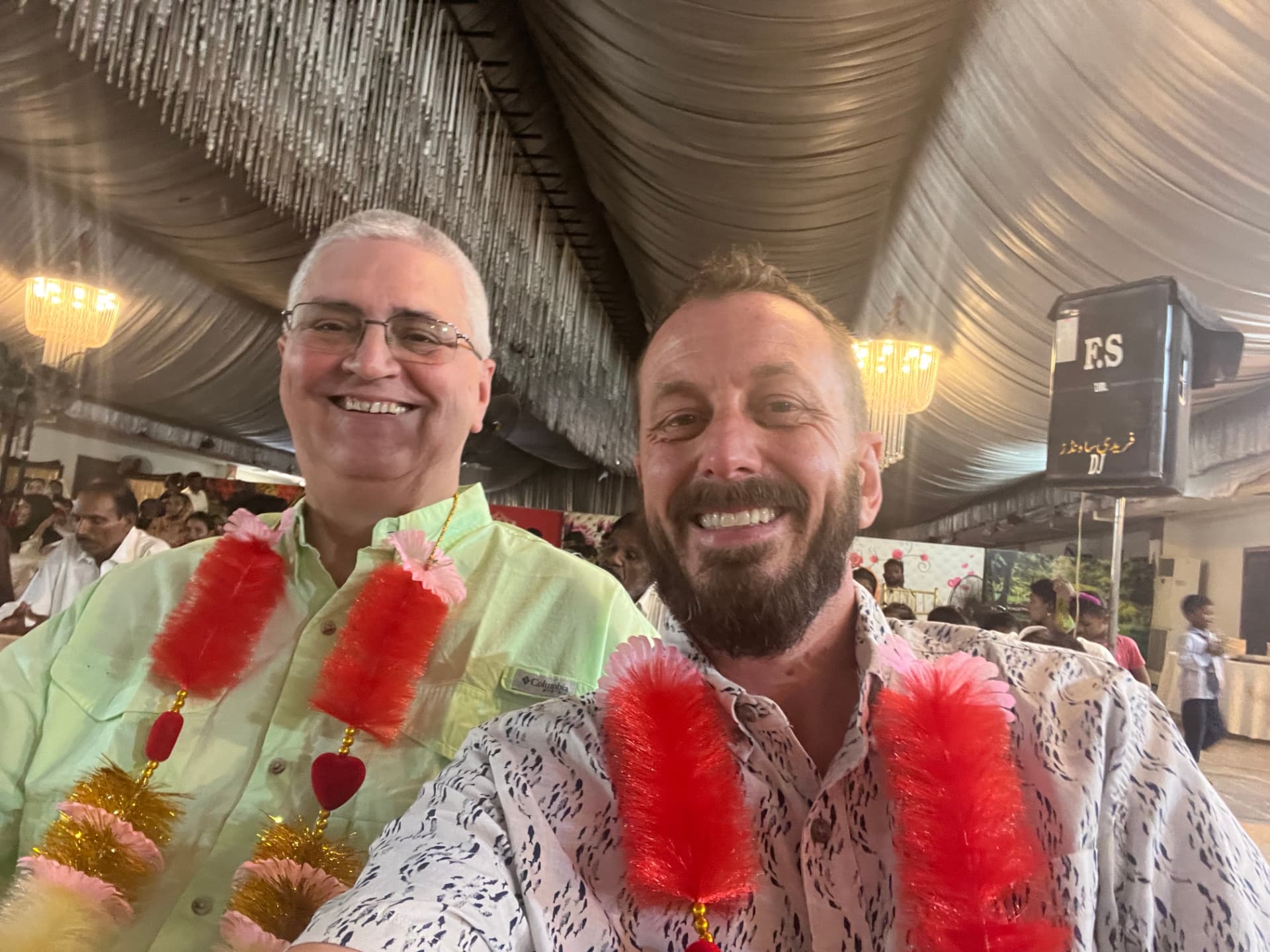 Two ministry leaders wearing celebratory garlands at a gathering in Pakistan