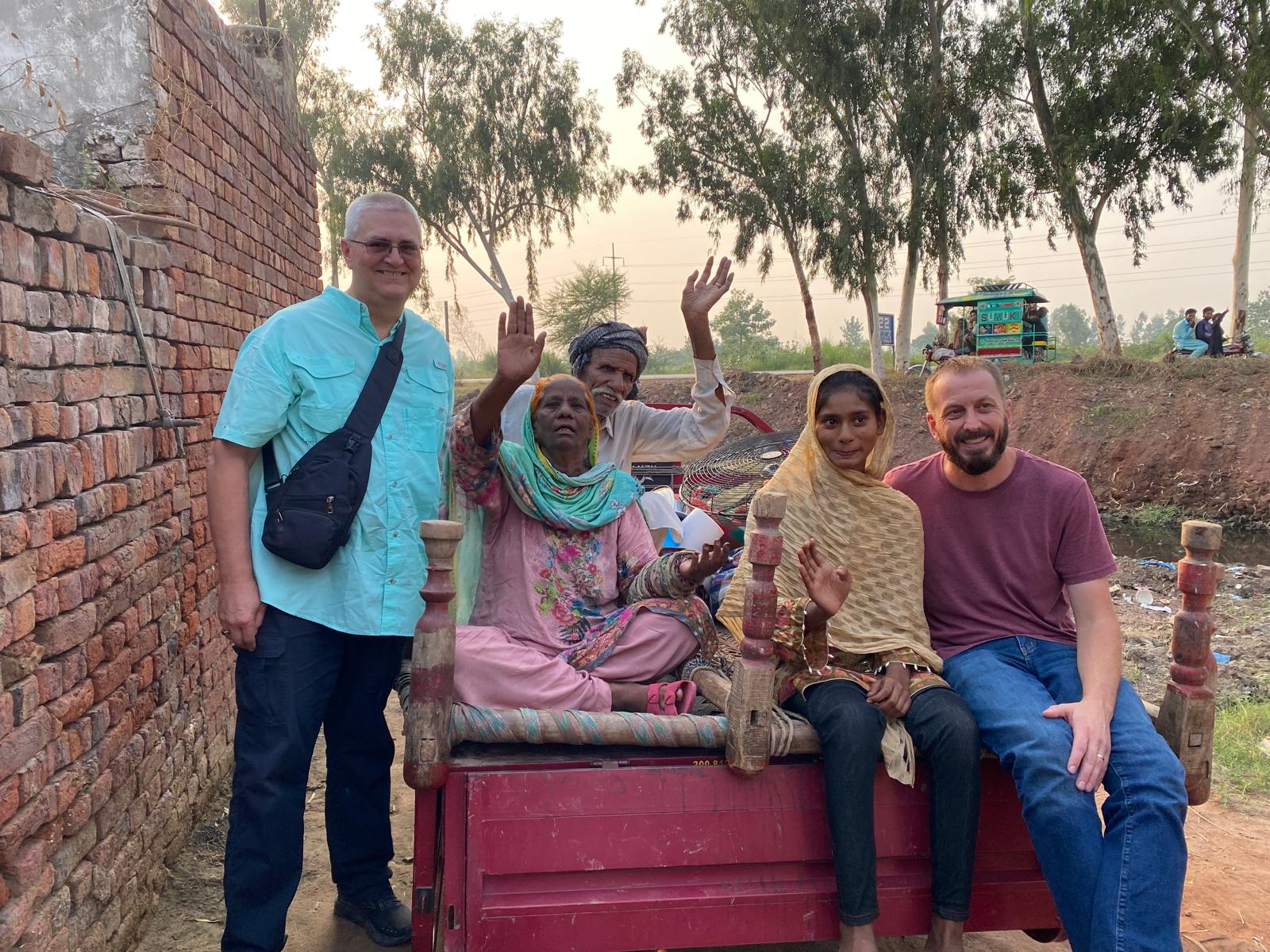 Ministry partners and a freed family waving from a cart in Pakistan