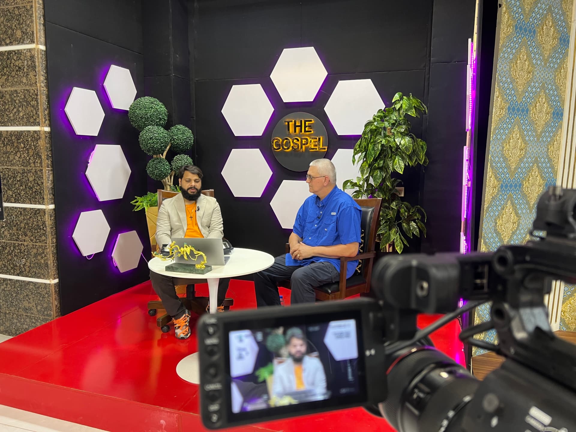 Two ministry leaders seated together during a television interview about the Gospel in Pakistan