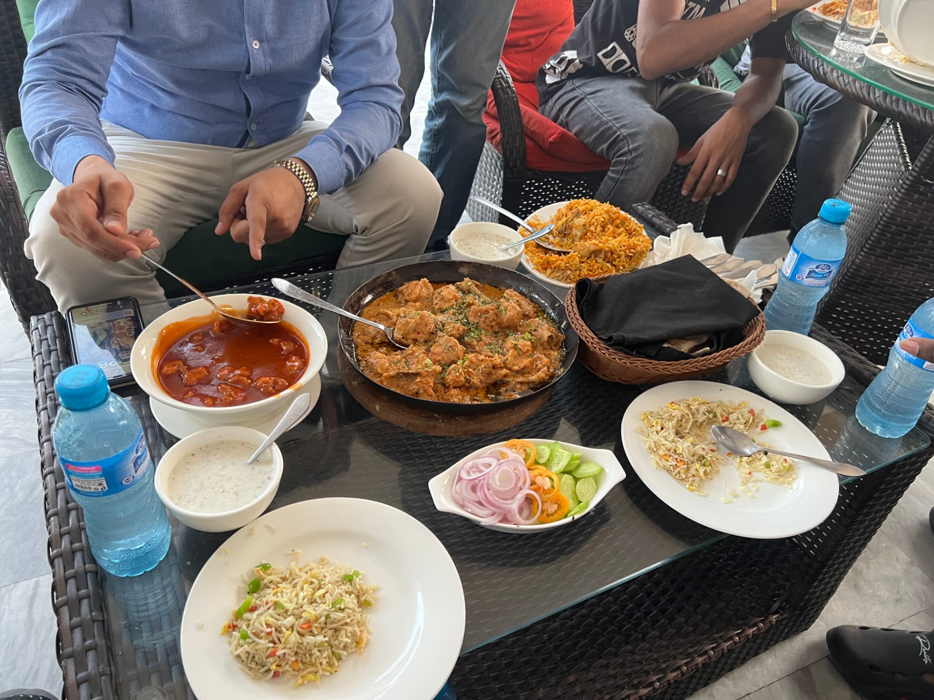 A shared meal of Pakistani dishes among ministry partners and friends