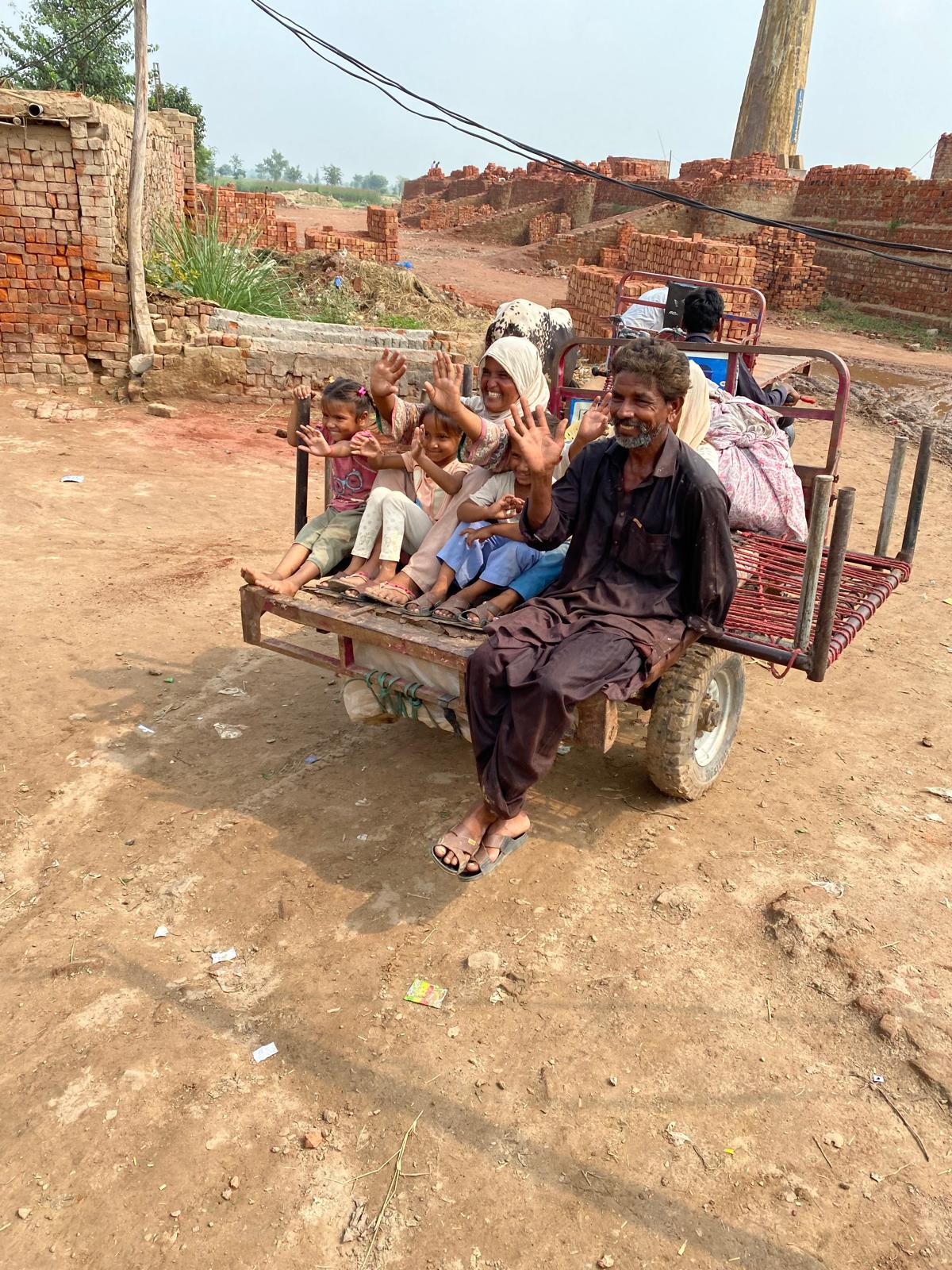 A family traveling by cart in a rural brick-making community in Pakistan