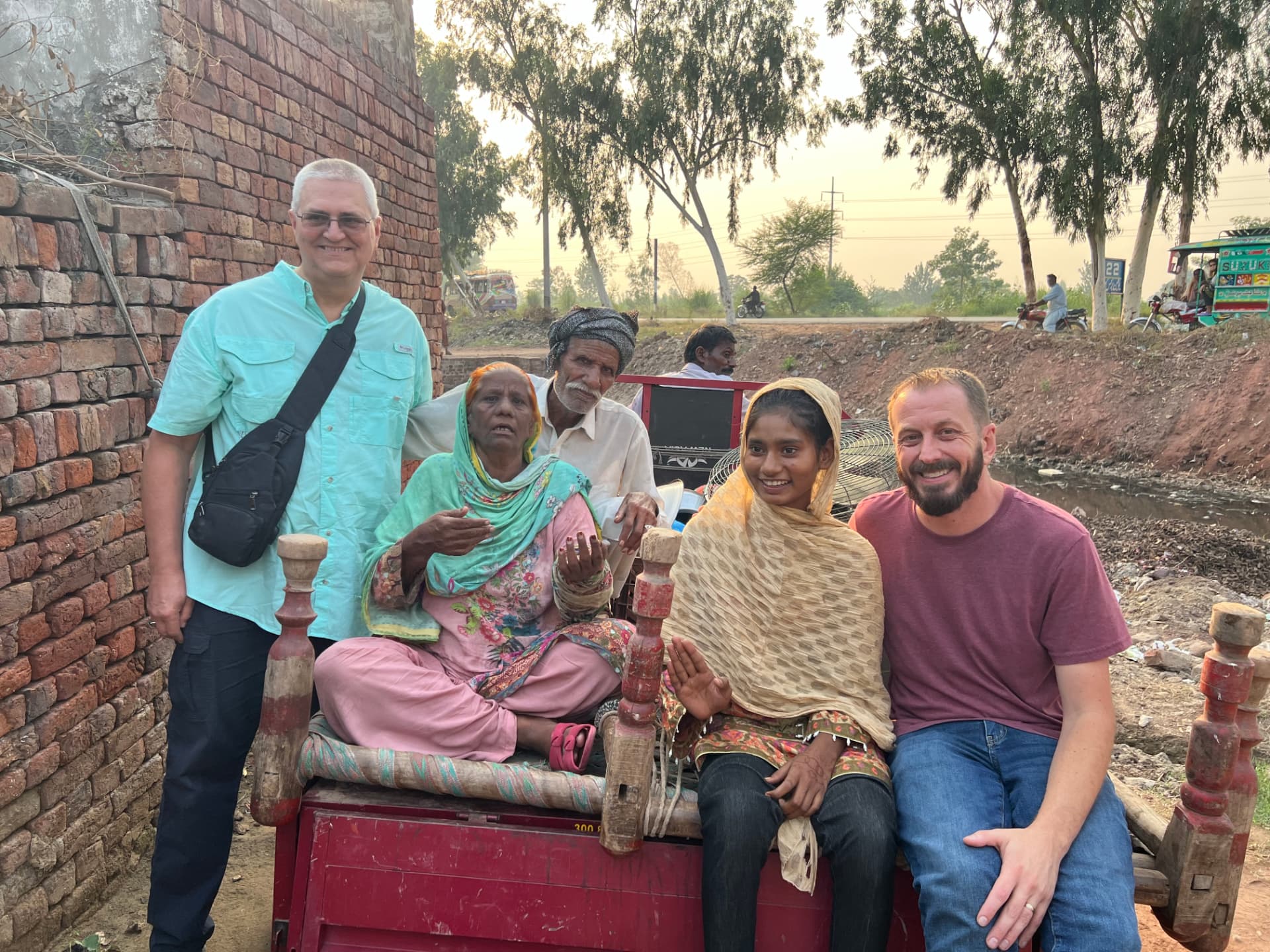 Ministry partners and a freed family seated together on a cart in Pakistan