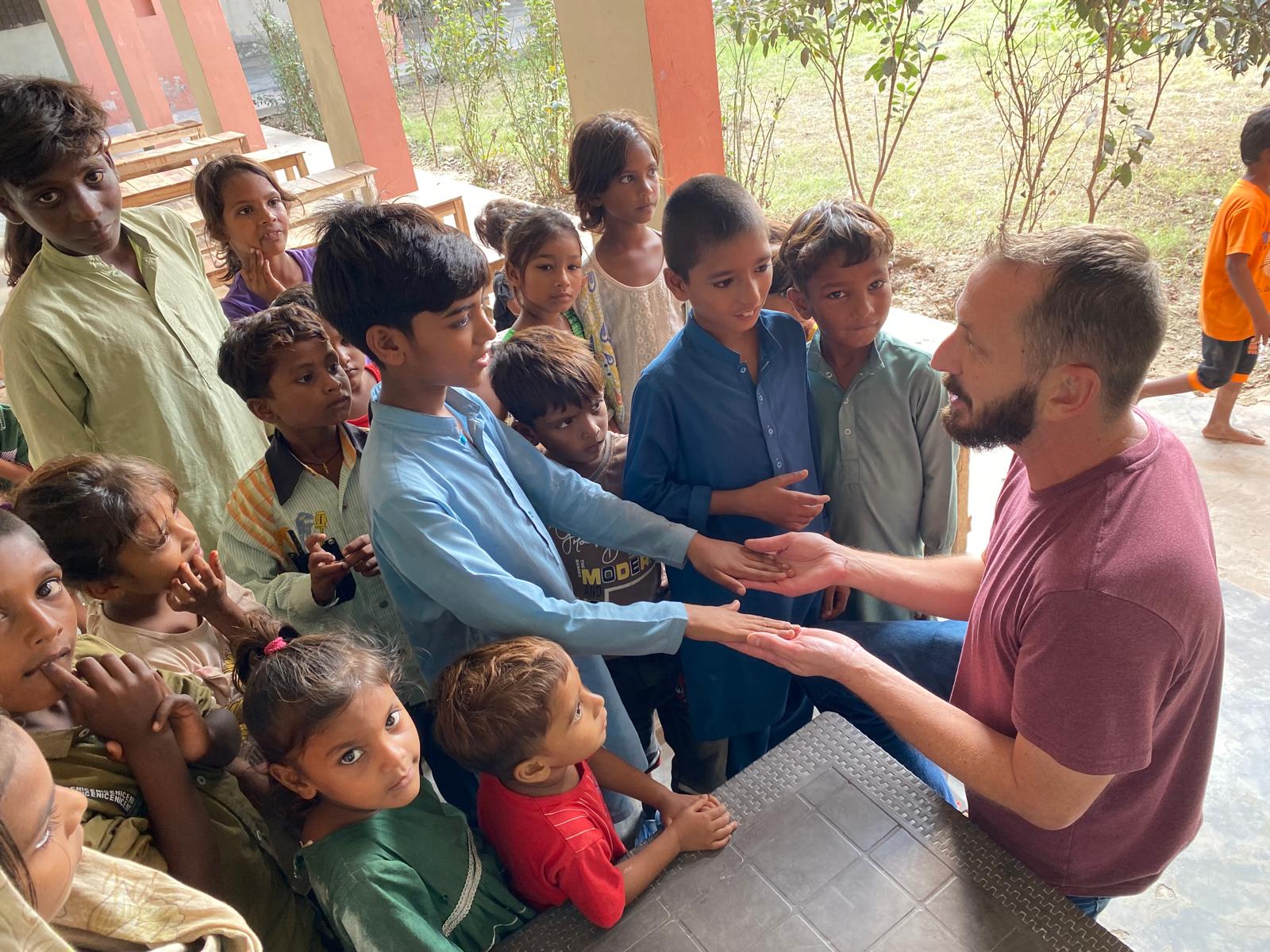 A ministry partner praying with children in Pakistan