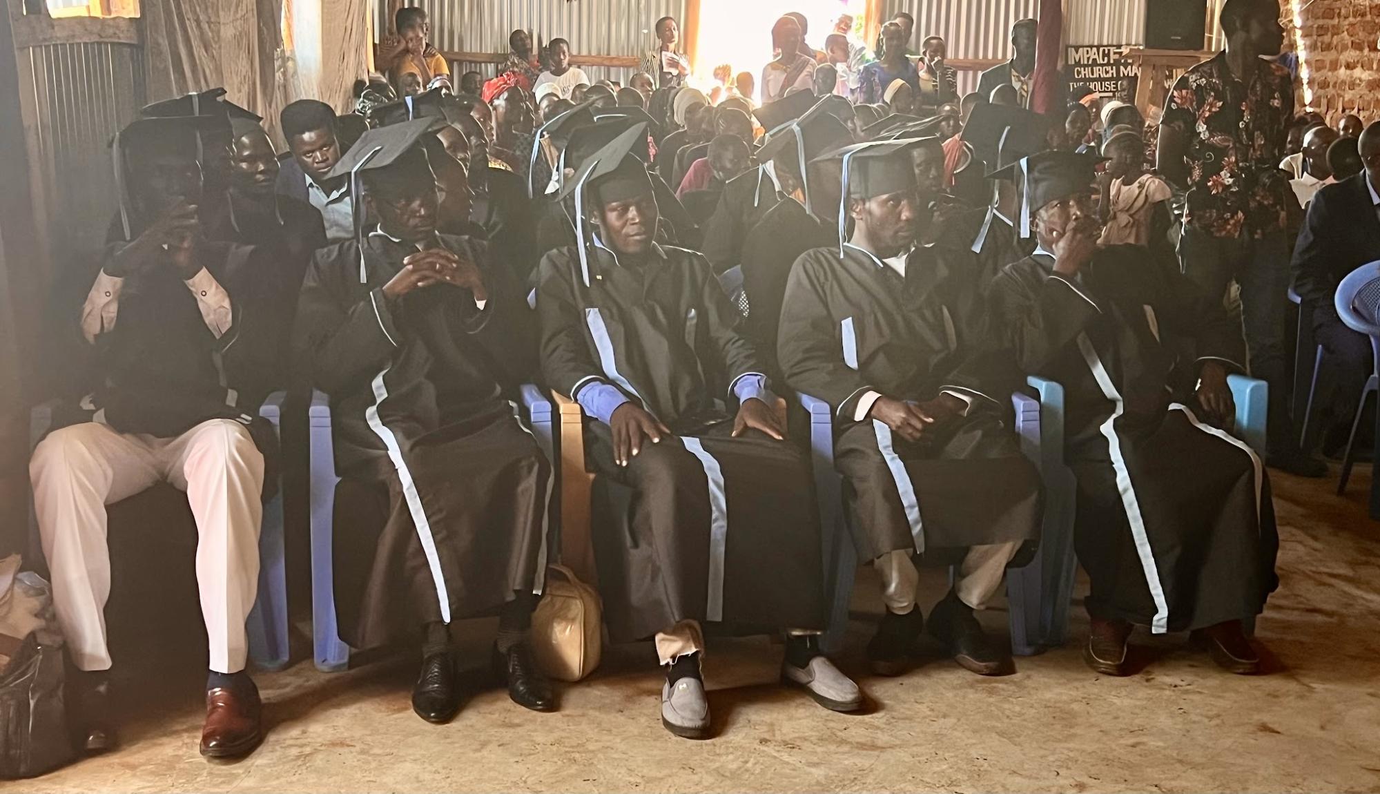 Ministry school graduates seated in caps and gowns inside a church