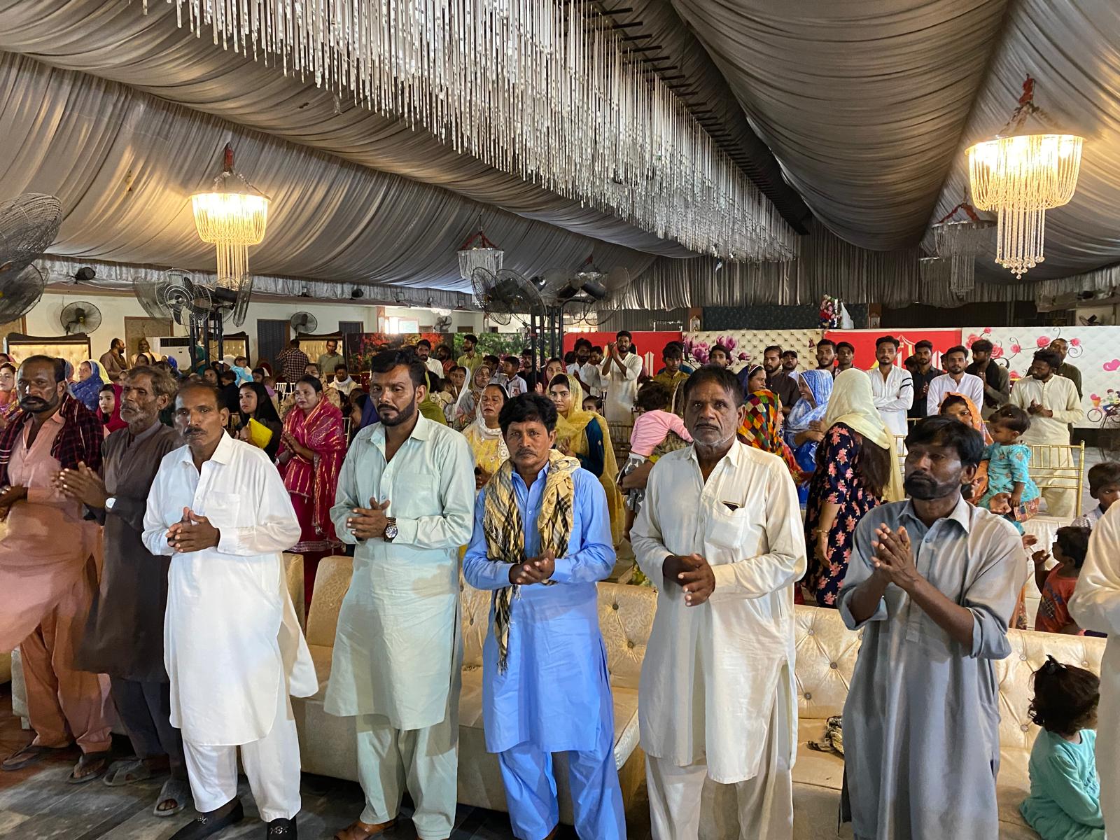 A congregation standing in prayer during a gathering in Pakistan