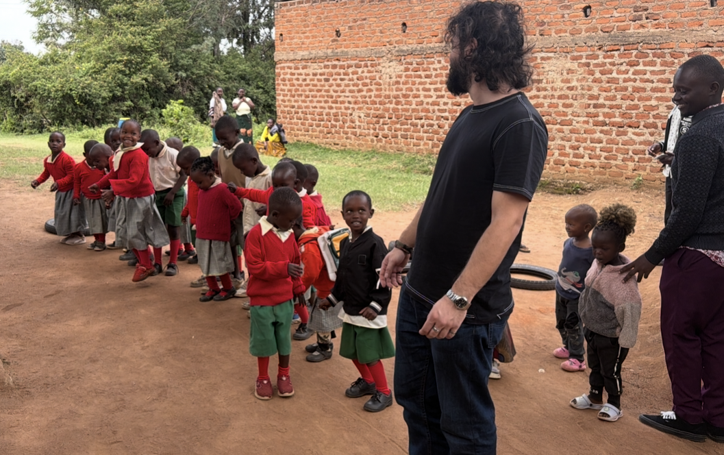 Team member greeting schoolchildren lined up outside their classroom