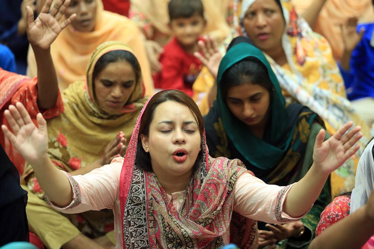 Women praying together during a gathering in Pakistan