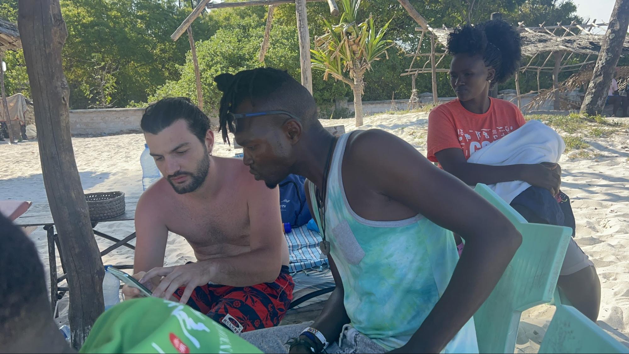 Team member studying Scripture with two friends on the beach