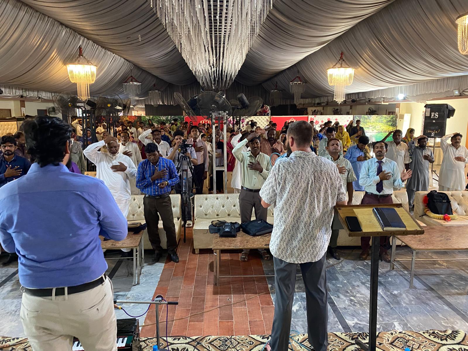 A ministry leader teaching a large congregation in Pakistan