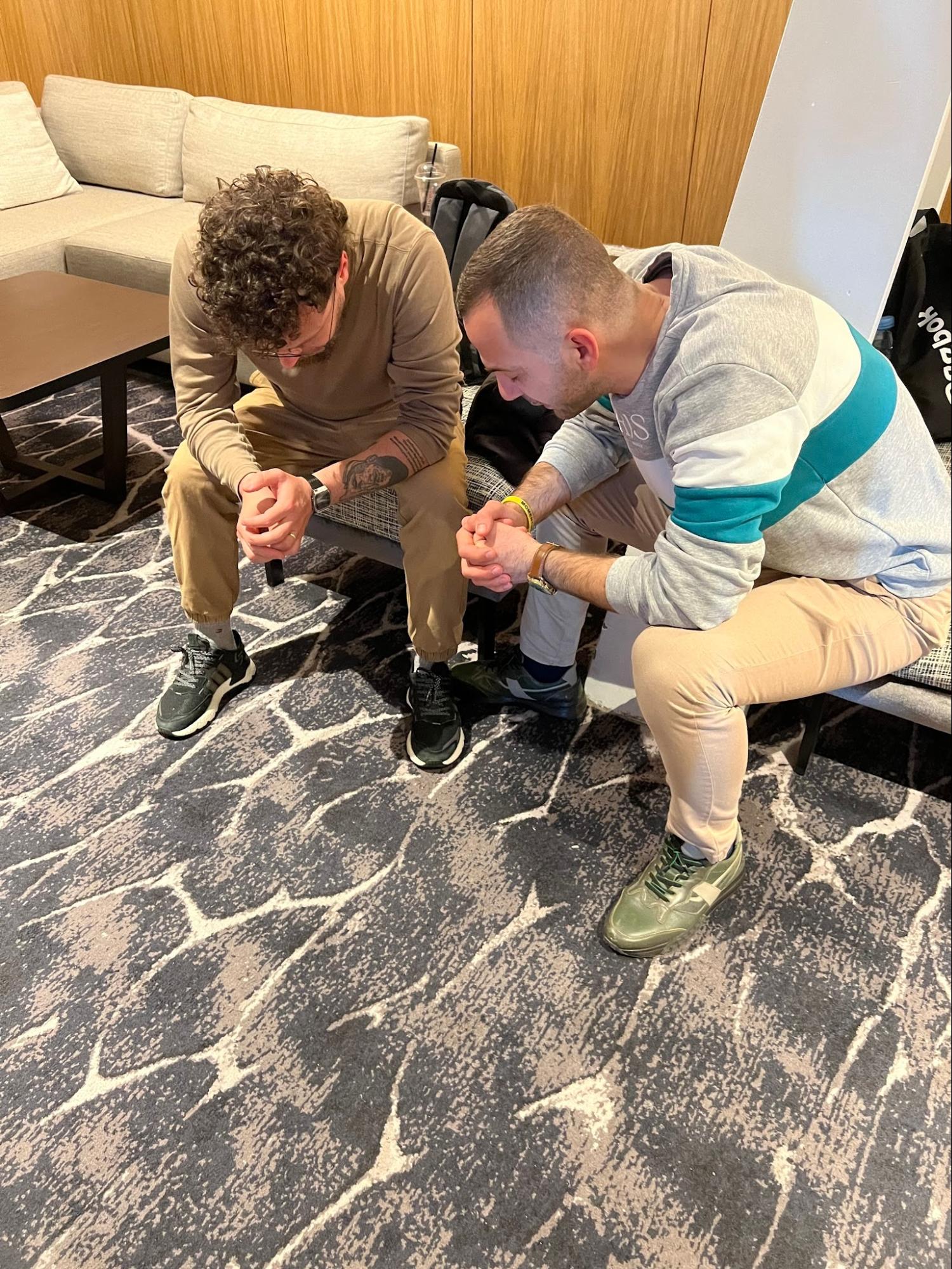 Two men praying together side by side