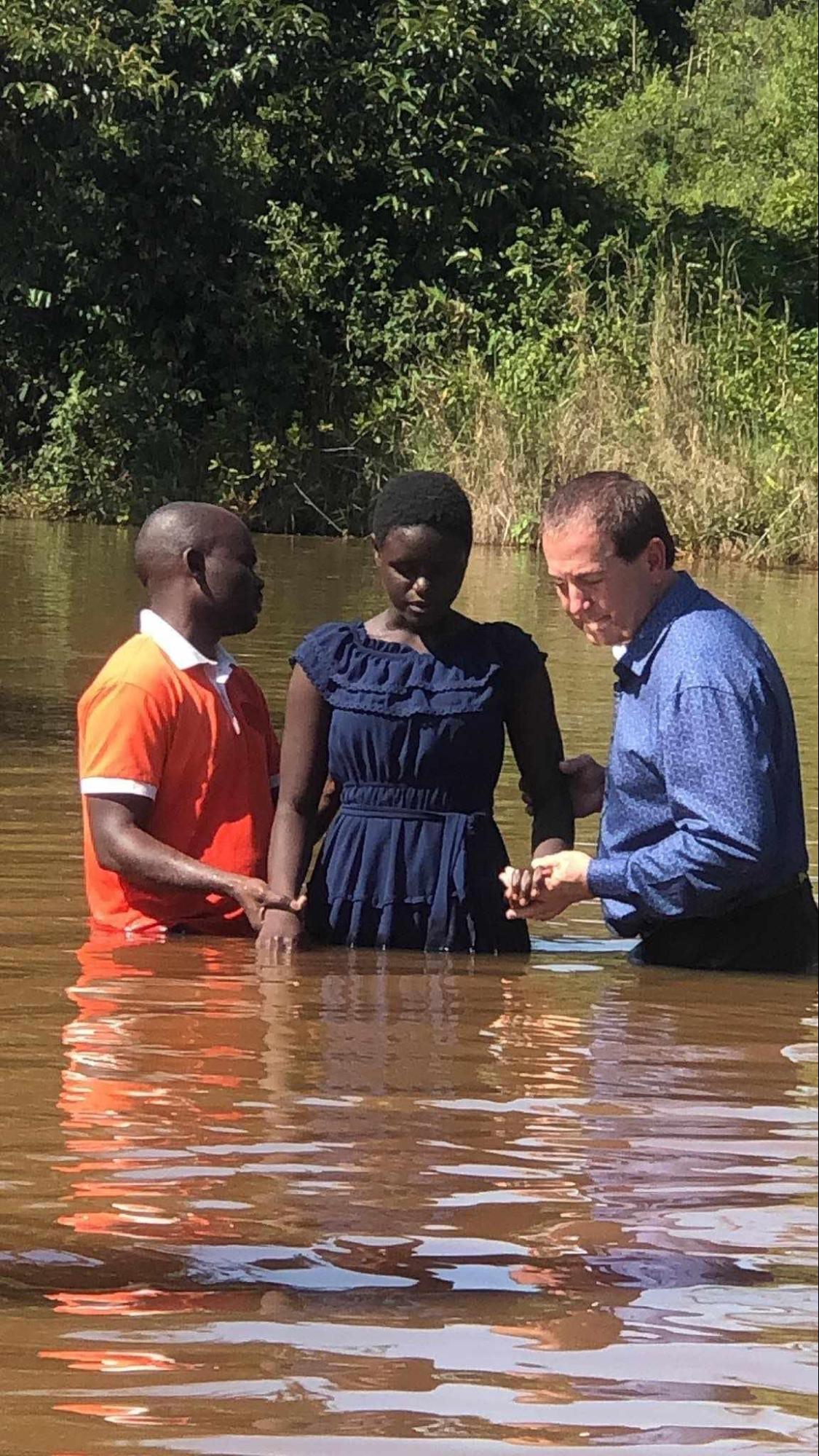 Young woman being baptized in a river