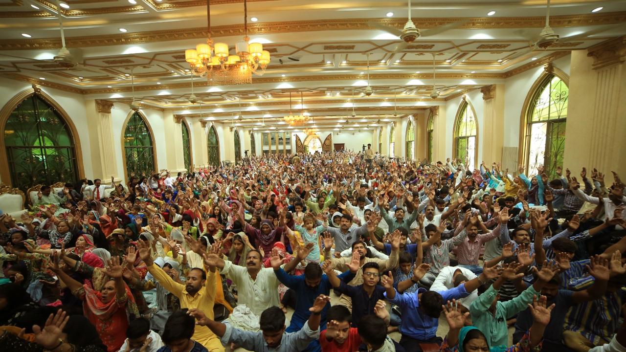 A congregation raising their hands in worship in Pakistan