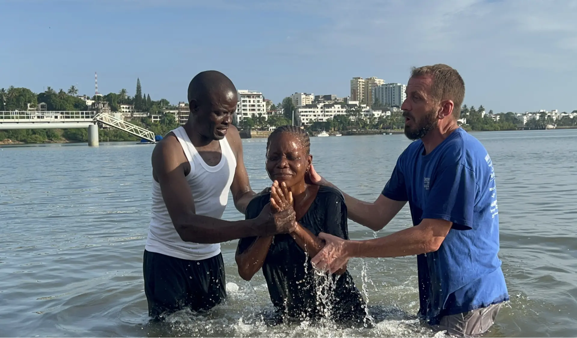 Woman being baptized in the water by two ministry leaders