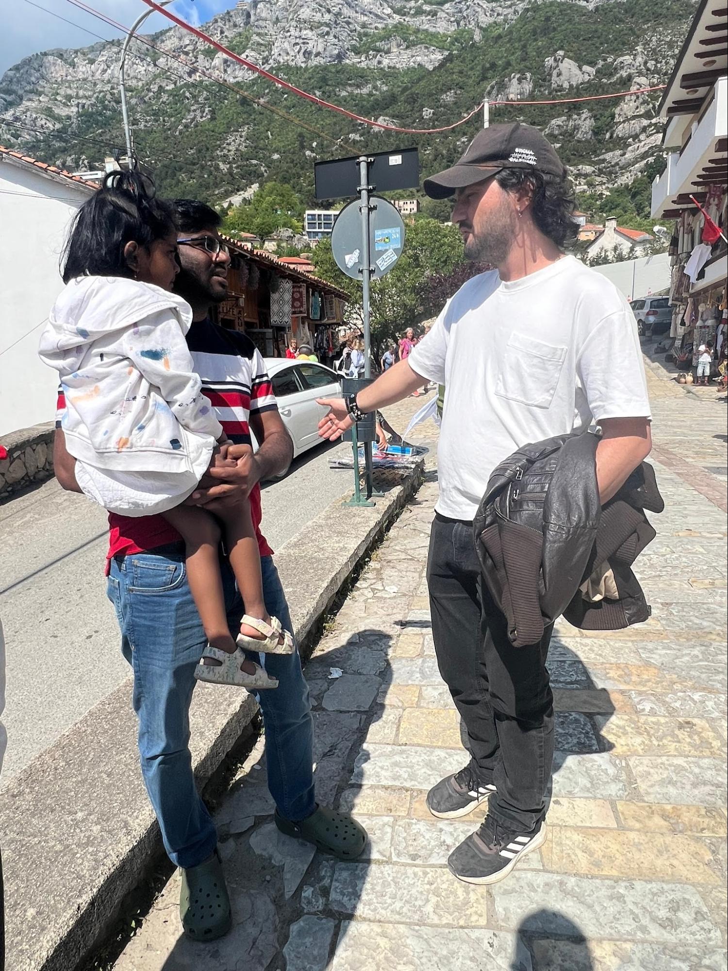Team member sharing the Gospel with a father and daughter on a mountain street