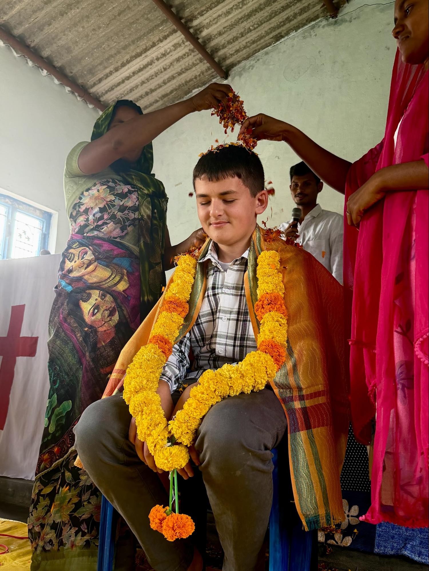 Young visitor honored with flower garlands during a church welcome