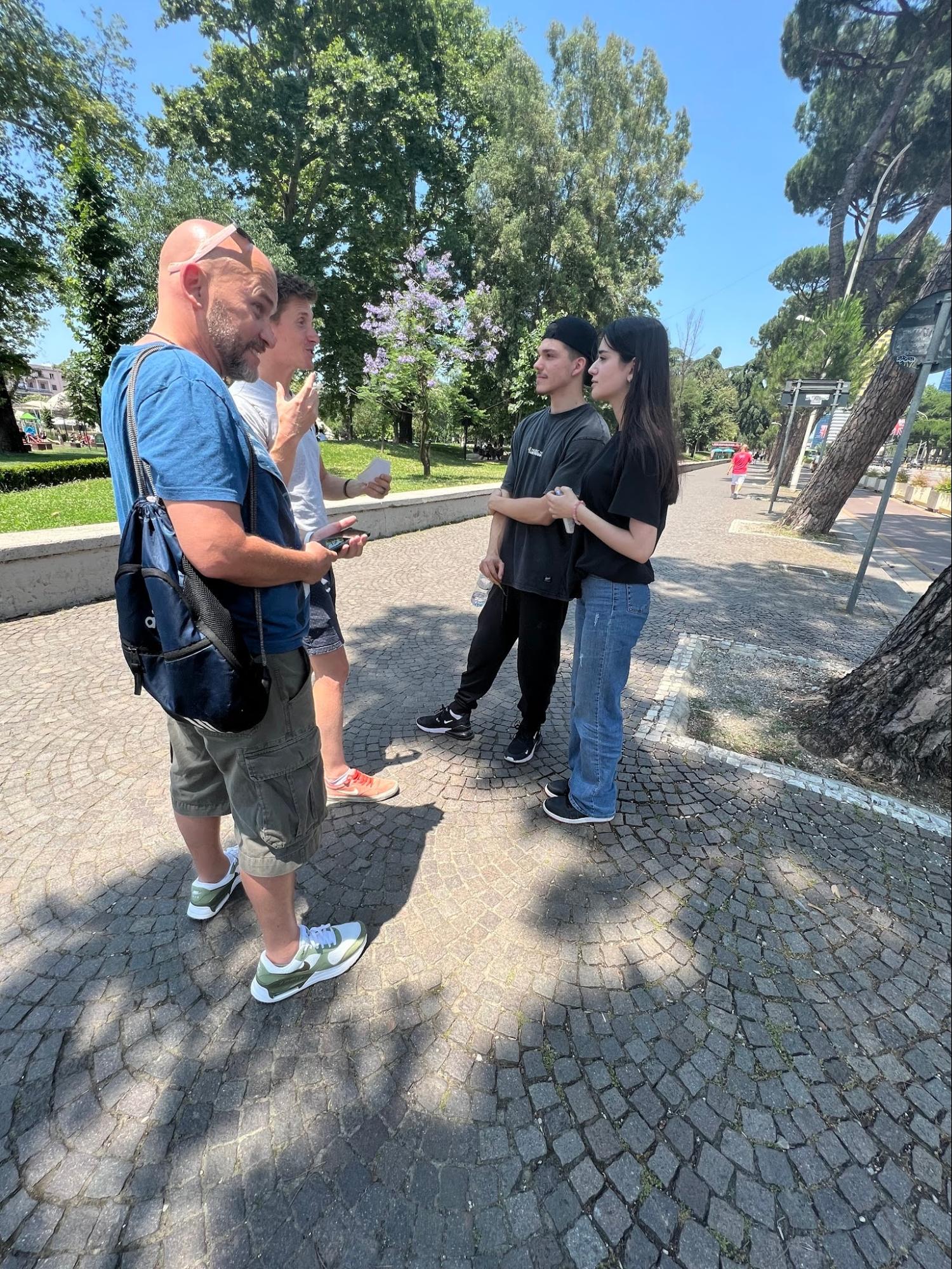 Team members sharing the Gospel with two young people in a city park