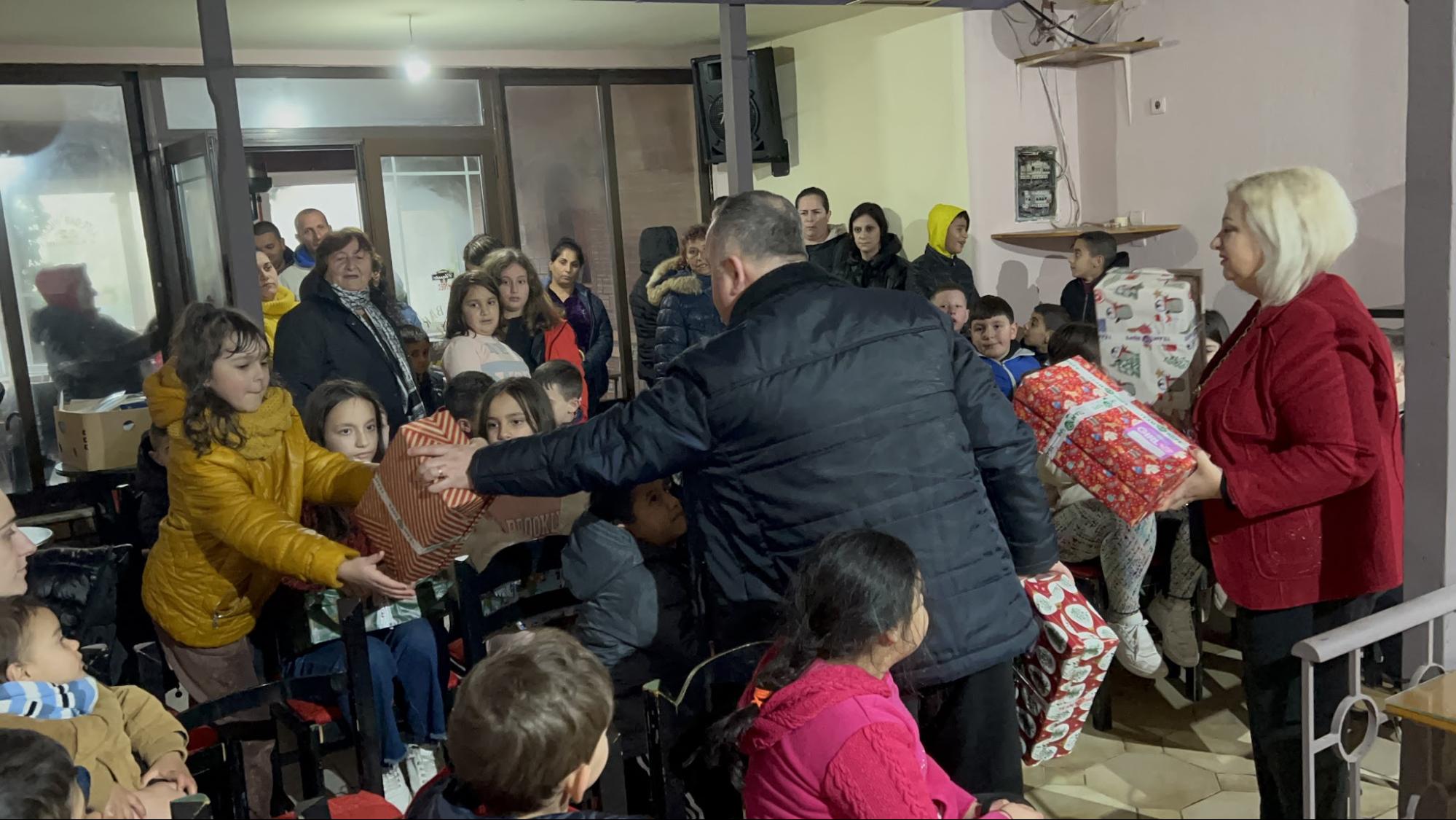 Children receiving Christmas gift boxes at a community outreach