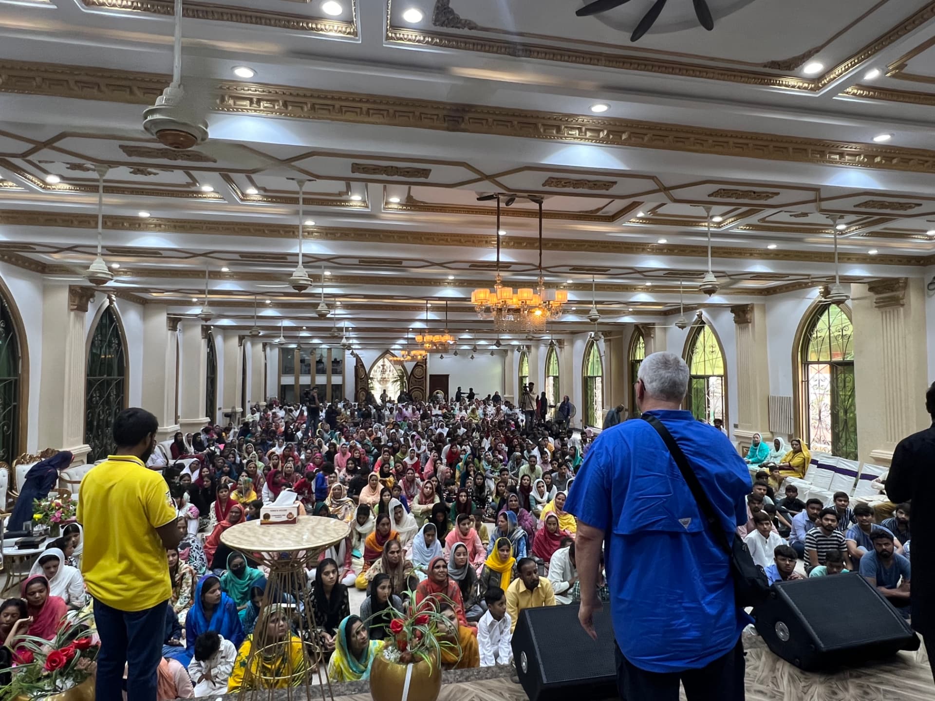 A large congregation gathered inside an ornate hall in Pakistan
