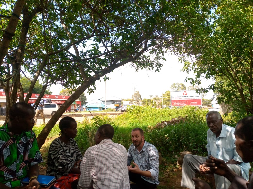 Small group discussion under a shade tree