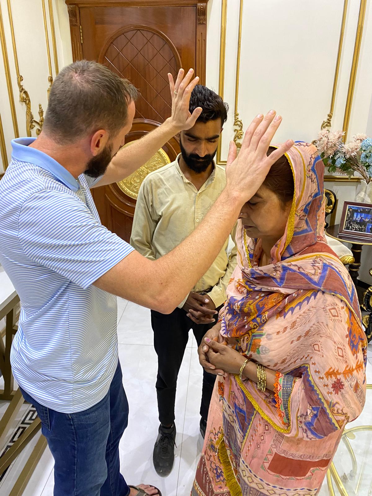 A ministry partner praying for a couple in Pakistan