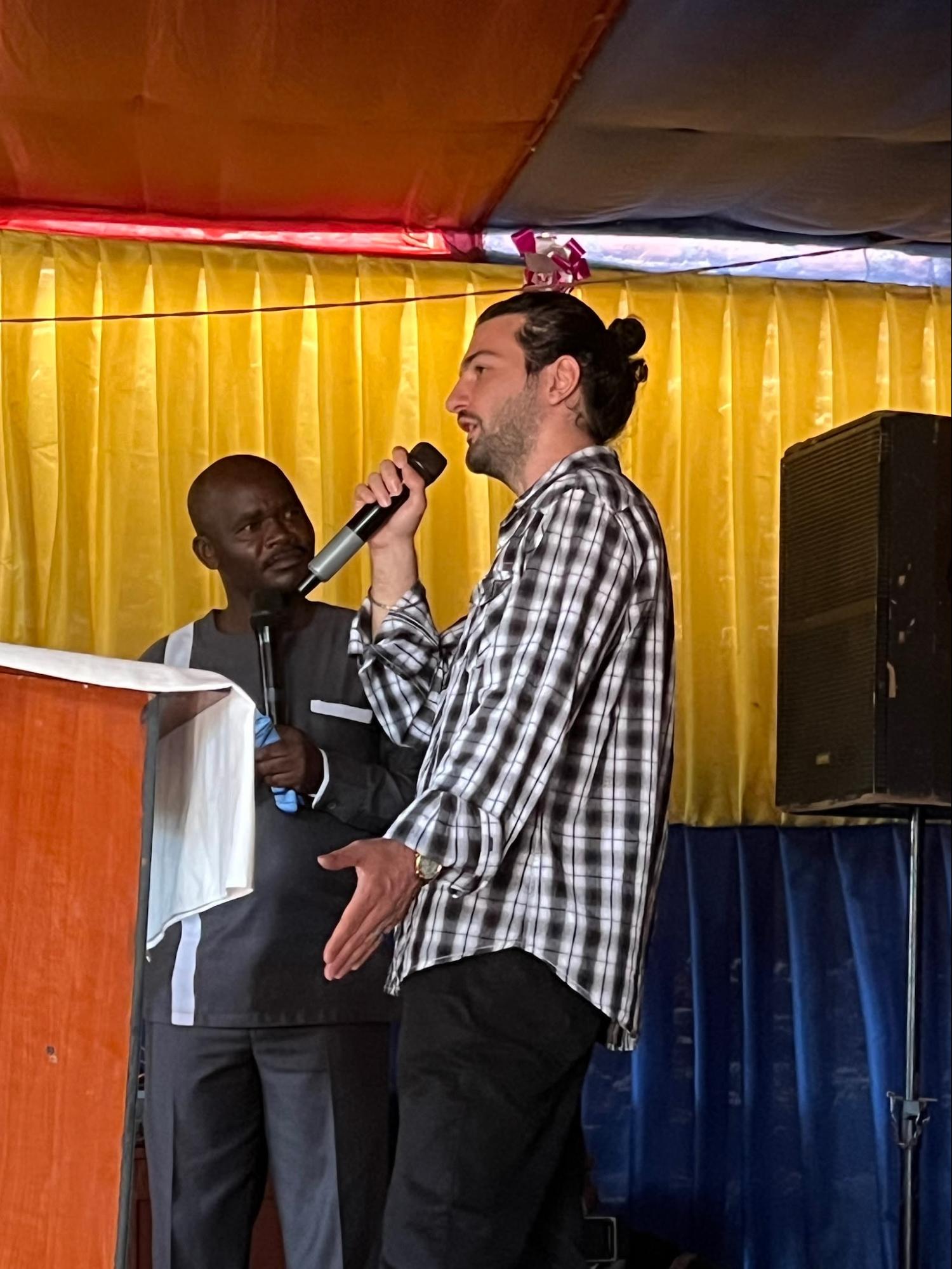 Team member preaching with a translator at an outdoor gathering